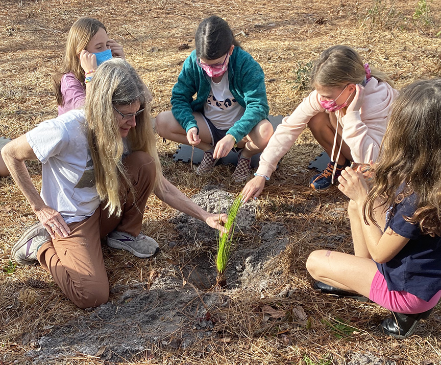 Kids planting a native plant